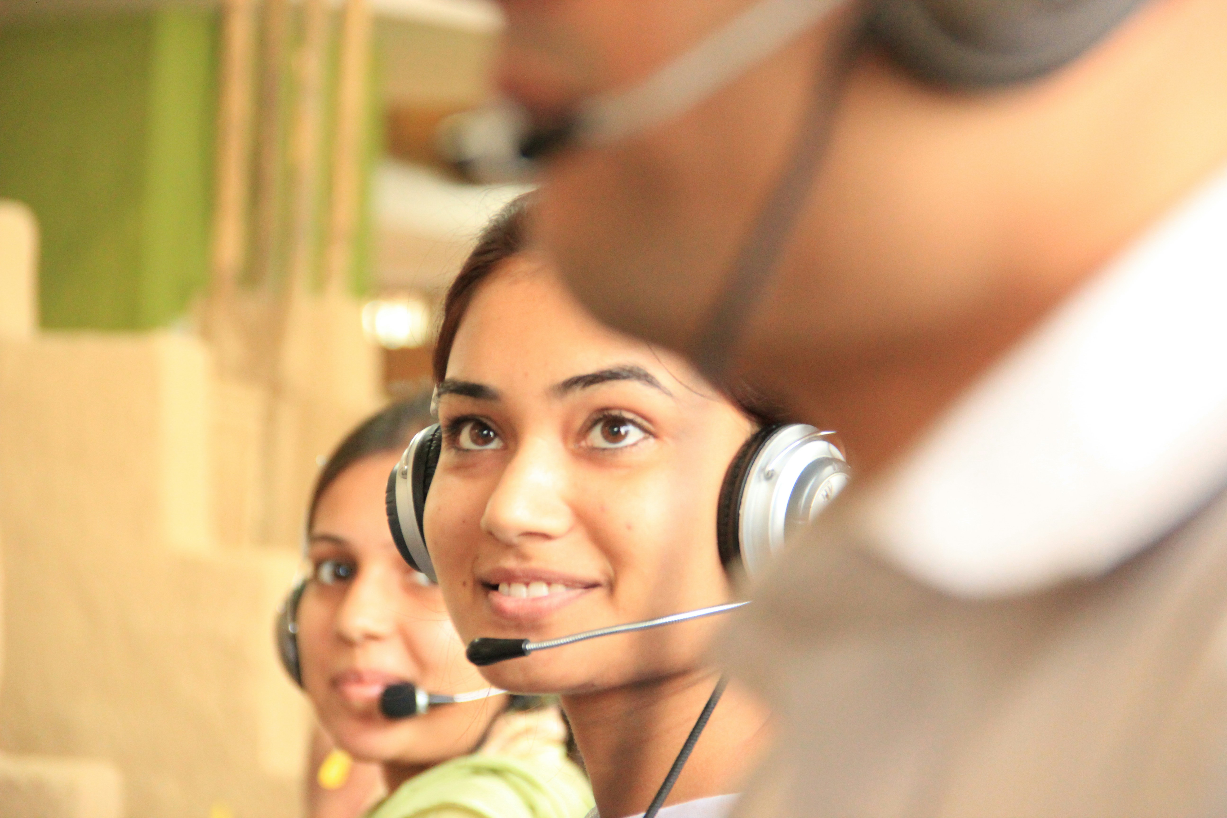 Atendente de suporte sorrindo com headset durante um atendimento